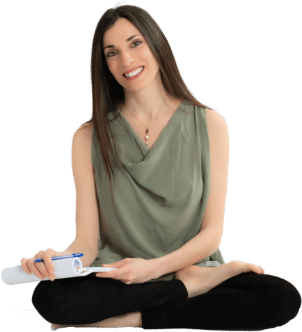 Angela Mezzolani, psicologa, in posizione yoga con un quaderno per gli appunti